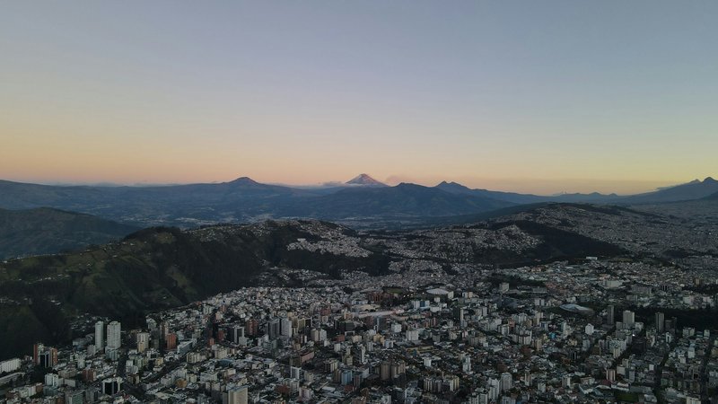 Ciudad al crepúsculo con colinas y una montaña prominente, mostrando la visión de Mercurium Investech de transformar vidas a través de la educación financiera, el pensamiento a largo plazo y la creación de riqueza sostenible.